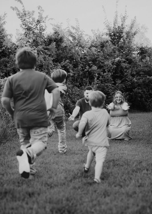 A black and white family photo of kids running to their parents 